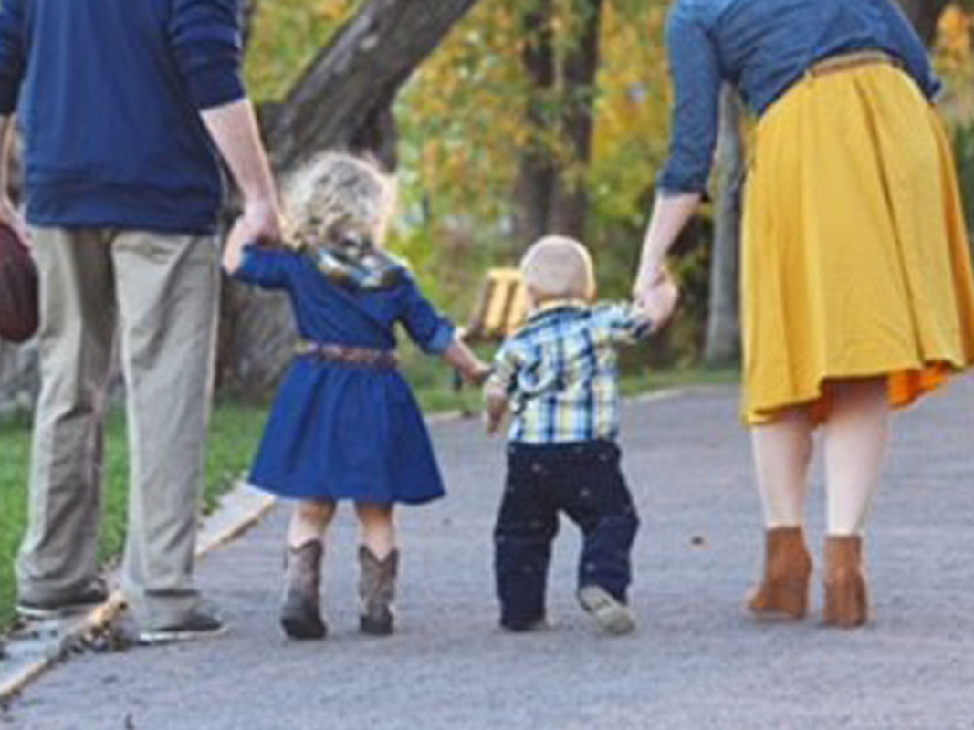 Couple Holding Hand Of Their Kids