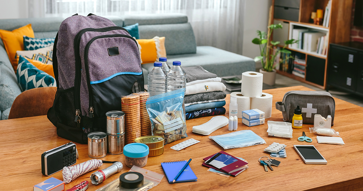 Emergency kit including water, canned food and more on a table